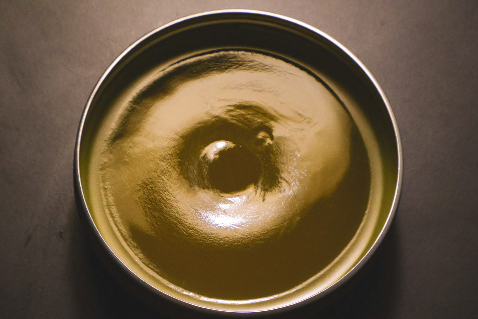 Healing Touch Salve in a tin — top down view of golden calendula and comfrey salve