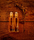 The Gentle Guardian Pocket Oil Roller — roller bottles on warm wood with dried goldenrod
