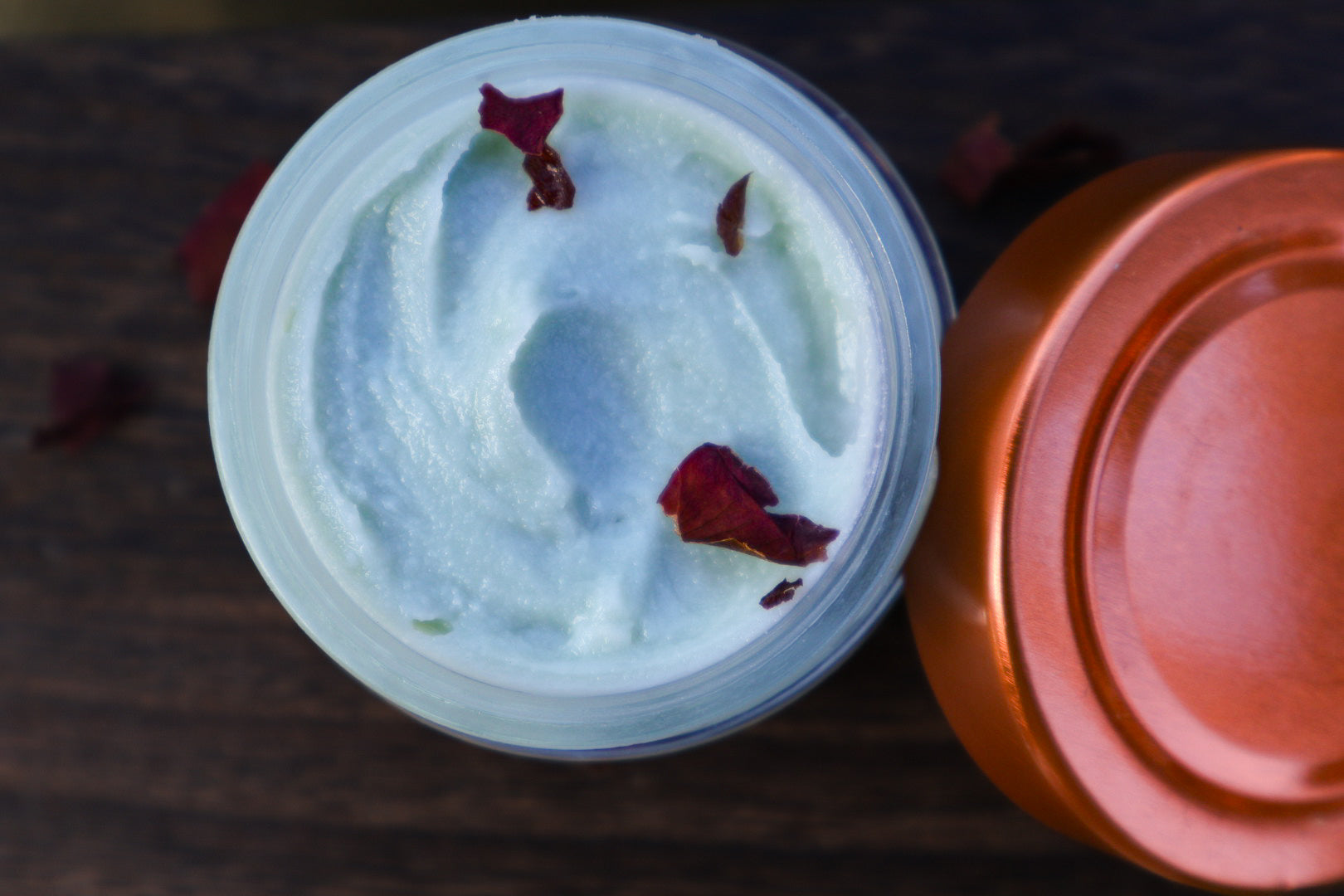 Copper Moon tallow cream open jar with rose petals, overhead view